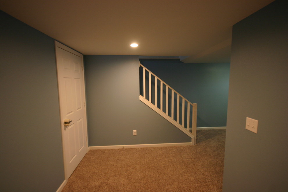 Aménagement d'un sous-sol classique enterré et de taille moyenne avec un mur bleu, moquette et aucune cheminée.