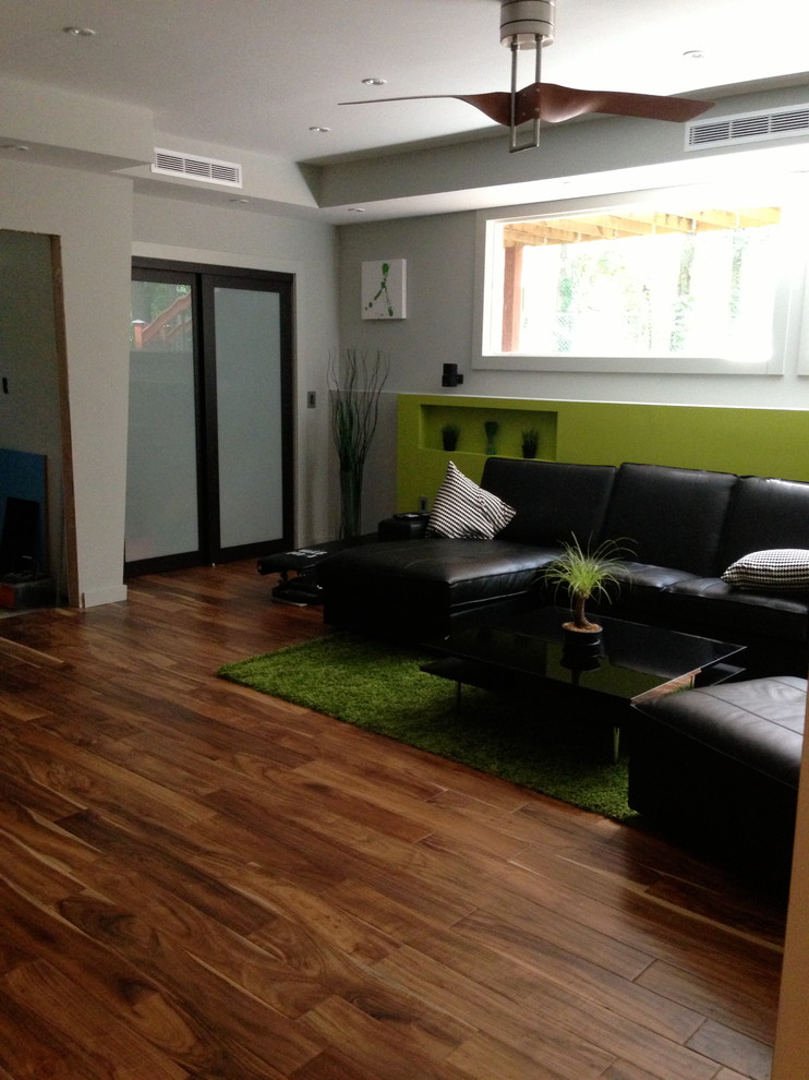 Idéer för funkis källare, med gröna väggar, mellanmörkt trägolv och brunt golv