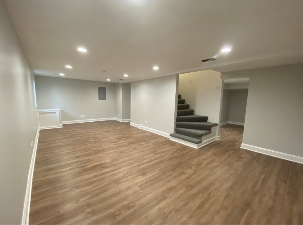 Design ideas for a small look-out basement in Chicago with grey walls, vinyl flooring, brown floors and panelled walls.