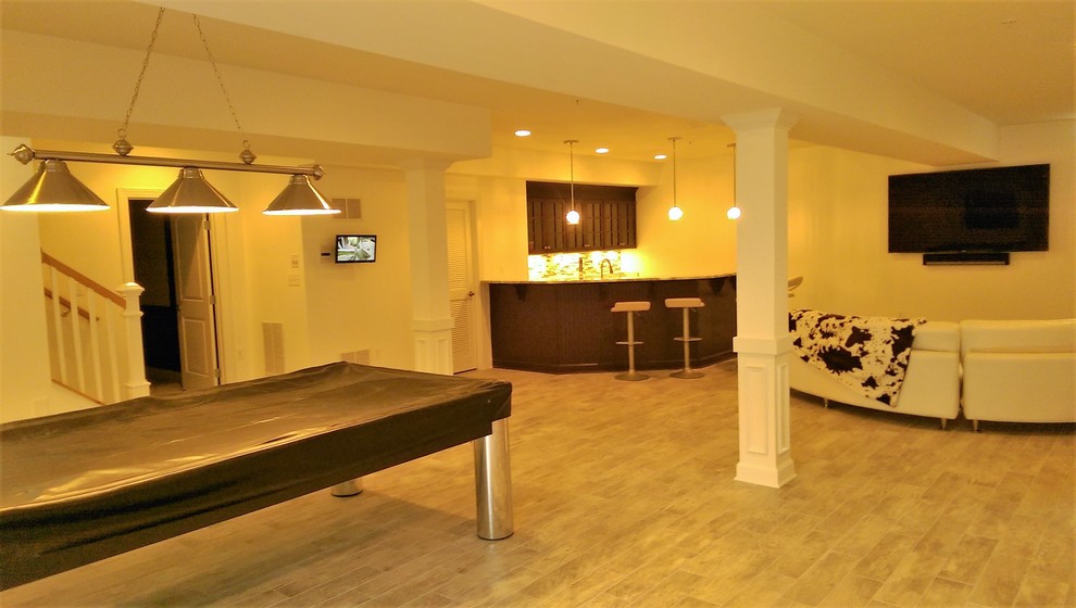 Immagine di un'ampia taverna tradizionale interrata con pareti bianche, pavimento in legno massello medio e pavimento marrone