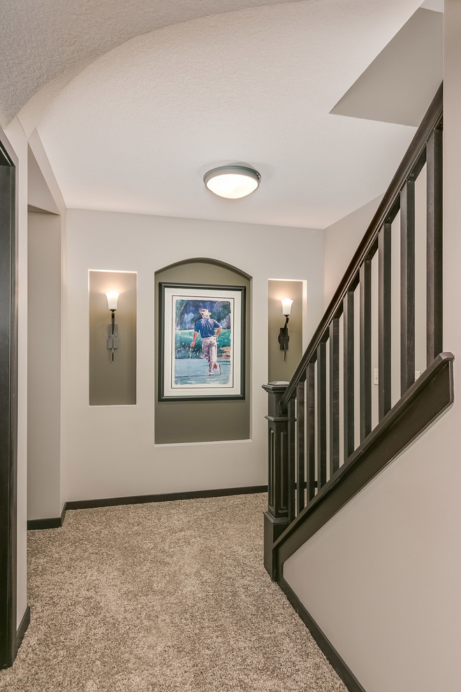 This is an example of a large classic walk-out basement in Minneapolis with carpet, grey walls, a ribbon fireplace, a metal fireplace surround and beige floors.