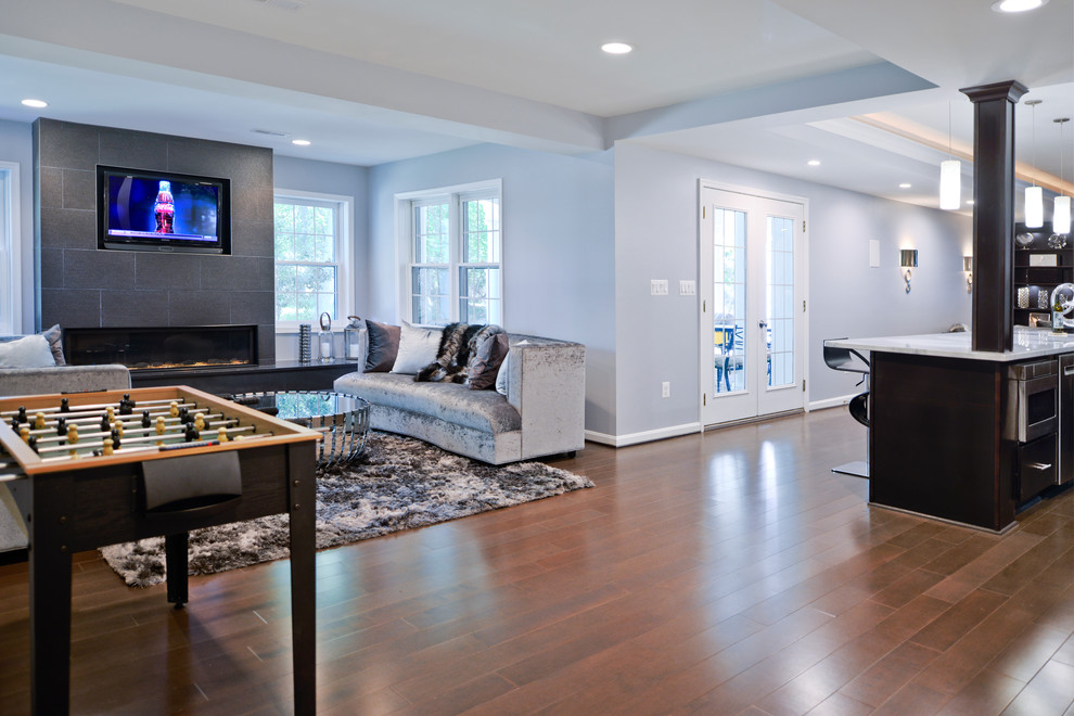 Large contemporary walk-out basement in DC Metro with blue walls, a standard fireplace, a stone fireplace surround and brown floors.