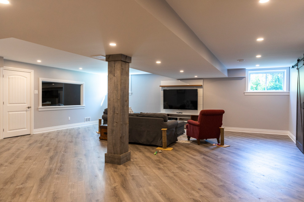 Basement - large contemporary underground laminate floor and brown floor basement idea in Ottawa with gray walls