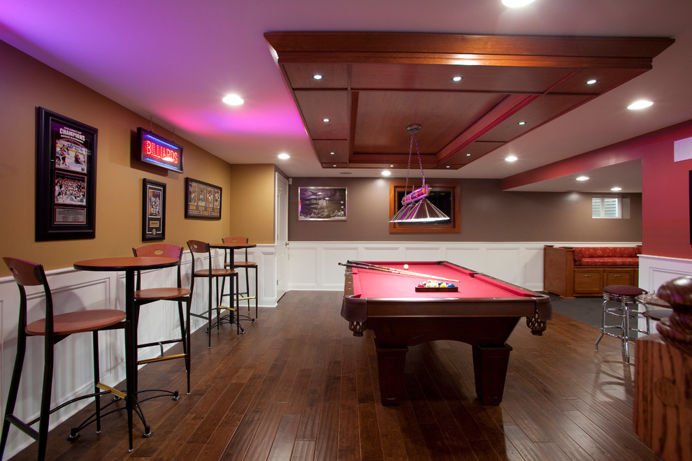 This is an example of a classic look-out basement in Chicago with brown walls, dark hardwood flooring and a dado rail.