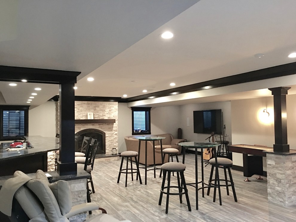 Inspiration for a mid-sized transitional underground dark wood floor and brown floor basement remodel in Chicago with beige walls, a standard fireplace and a stone fireplace