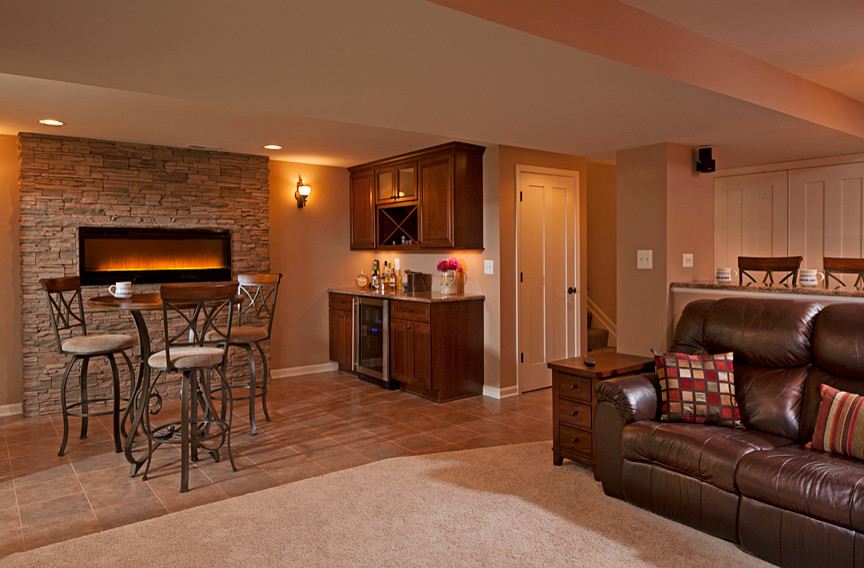 Example of a classic underground ceramic tile and orange floor basement design in Baltimore with beige walls, a ribbon fireplace and a stone fireplace