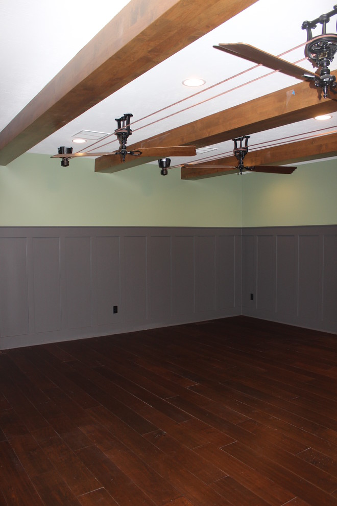 This is an example of a large classic walk-out basement in Salt Lake City with grey walls, medium hardwood flooring, a standard fireplace and a stone fireplace surround.