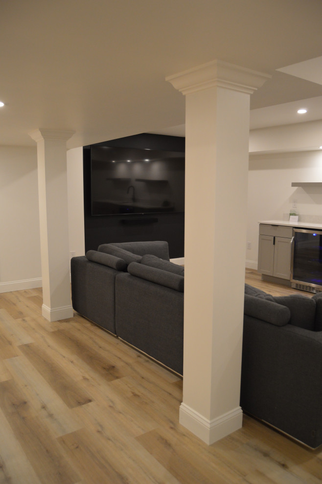 Exemple d'un sous-sol chic de taille moyenne avec un bar de salon, un mur blanc et un sol en vinyl.