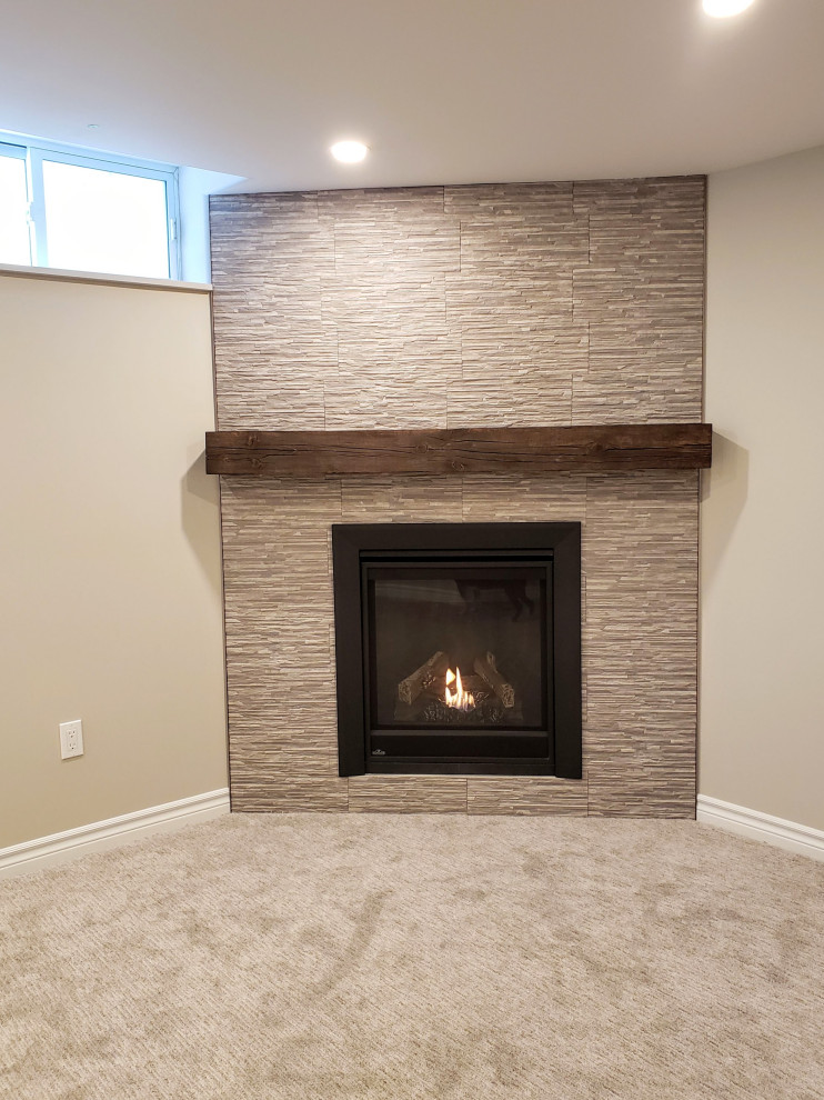 Mid-sized transitional look-out carpeted and gray floor basement photo in Toronto with beige walls, a corner fireplace and a tile fireplace