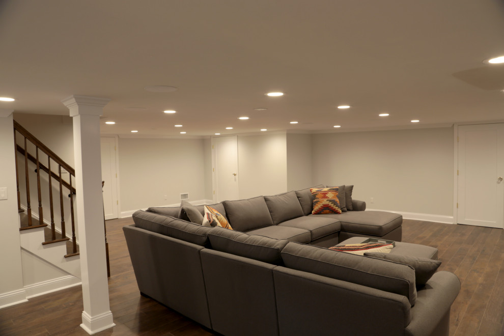 Large elegant laminate floor and brown floor basement photo in New York with beige walls