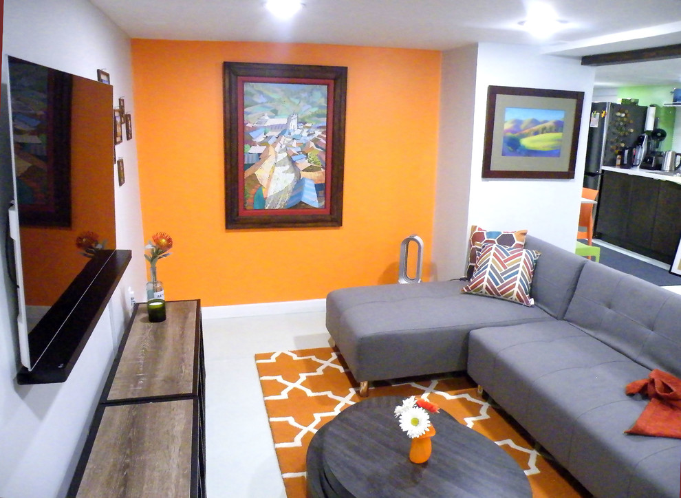 Exemple d'un sous-sol tendance de taille moyenne avec un mur orange, un sol en carrelage de porcelaine, aucune cheminée et un sol gris.