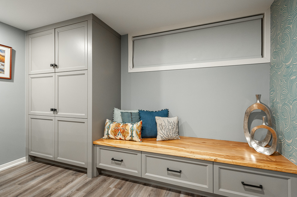 Imagen de sótano con ventanas de estilo americano pequeño sin chimenea con paredes azules, suelo laminado y suelo gris