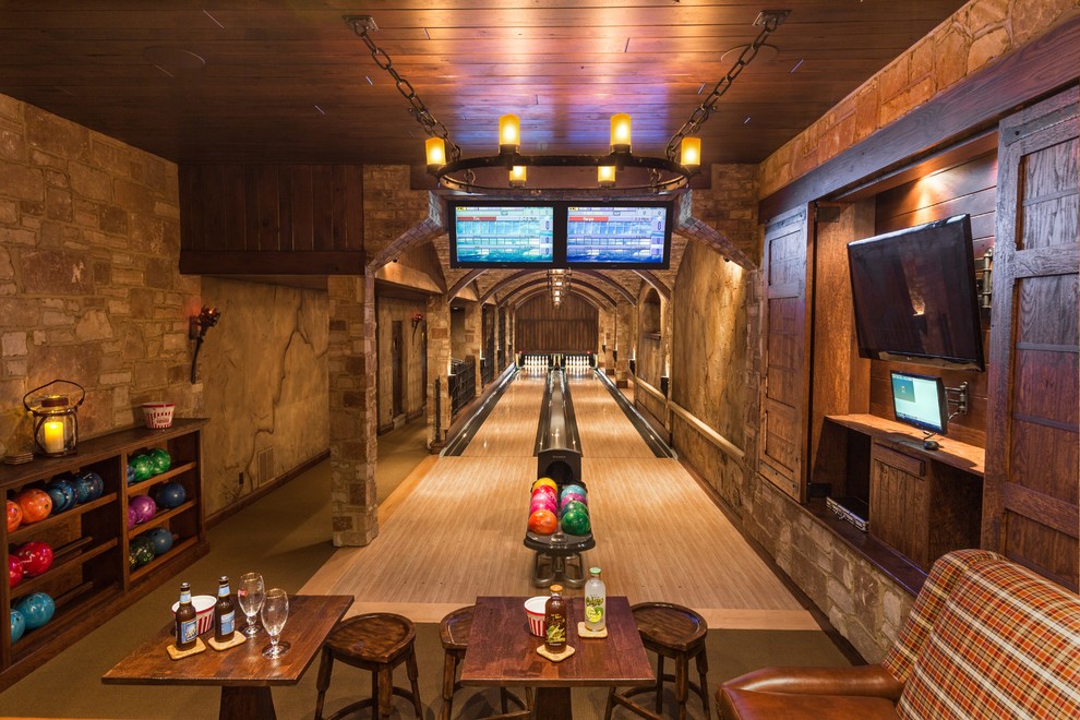 Basement game room - huge rustic underground basement game room idea in Milwaukee with brown walls and no fireplace