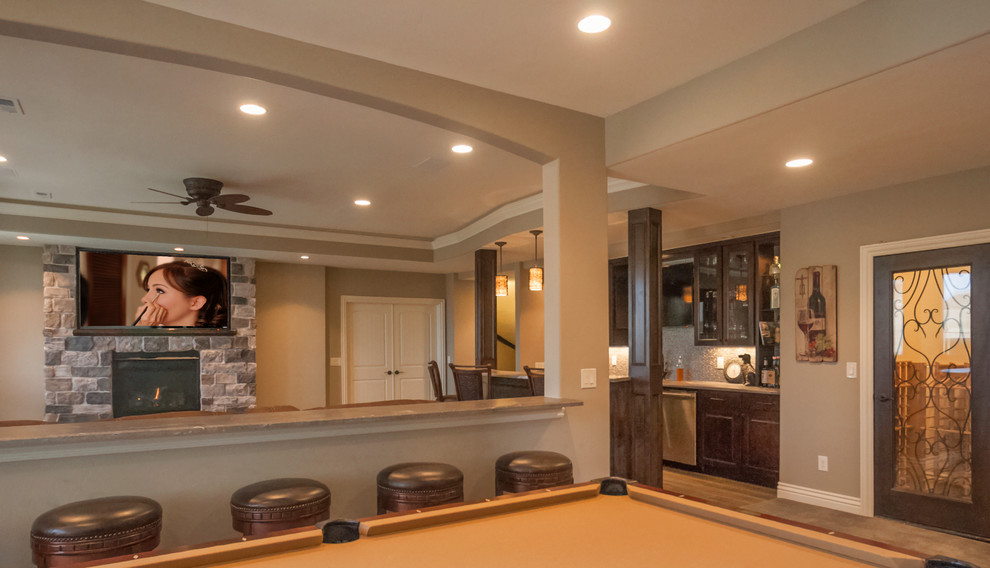 Basement - large transitional walk-out porcelain tile basement idea in Denver with beige walls, a standard fireplace and a stone fireplace