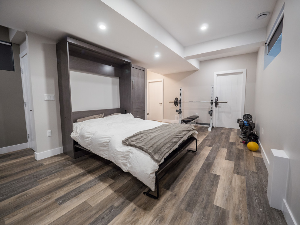 Design ideas for a medium sized contemporary look-out basement in Edmonton with grey walls, medium hardwood flooring, no fireplace and grey floors.