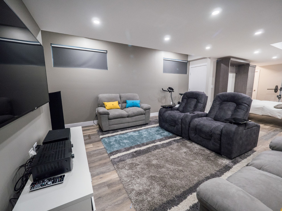 Example of a mid-sized trendy look-out medium tone wood floor and gray floor basement design in Edmonton with gray walls and no fireplace