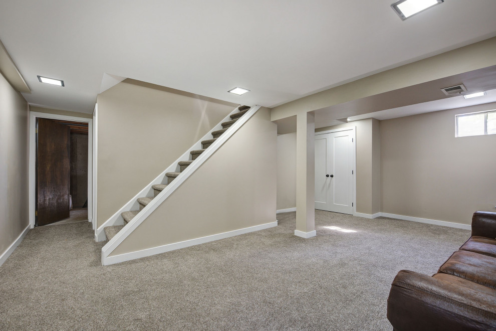 Medium sized traditional look-out basement in Denver with beige walls, carpet and grey floors.