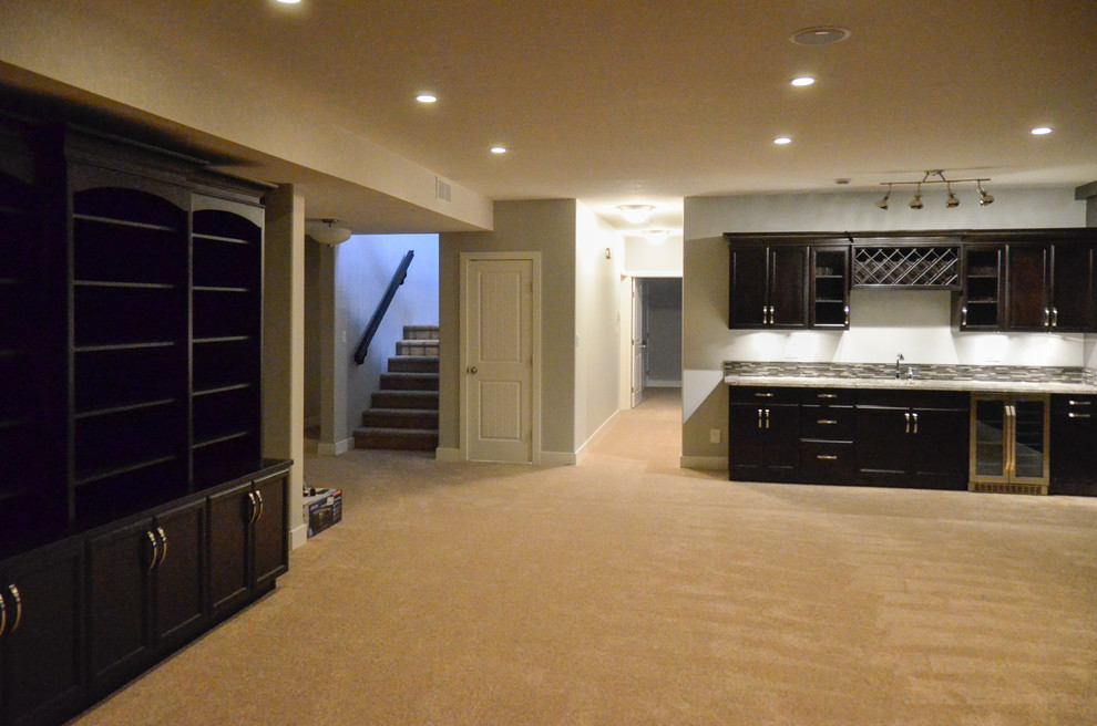 Example of a large classic underground carpeted and beige floor basement design in Calgary with gray walls
