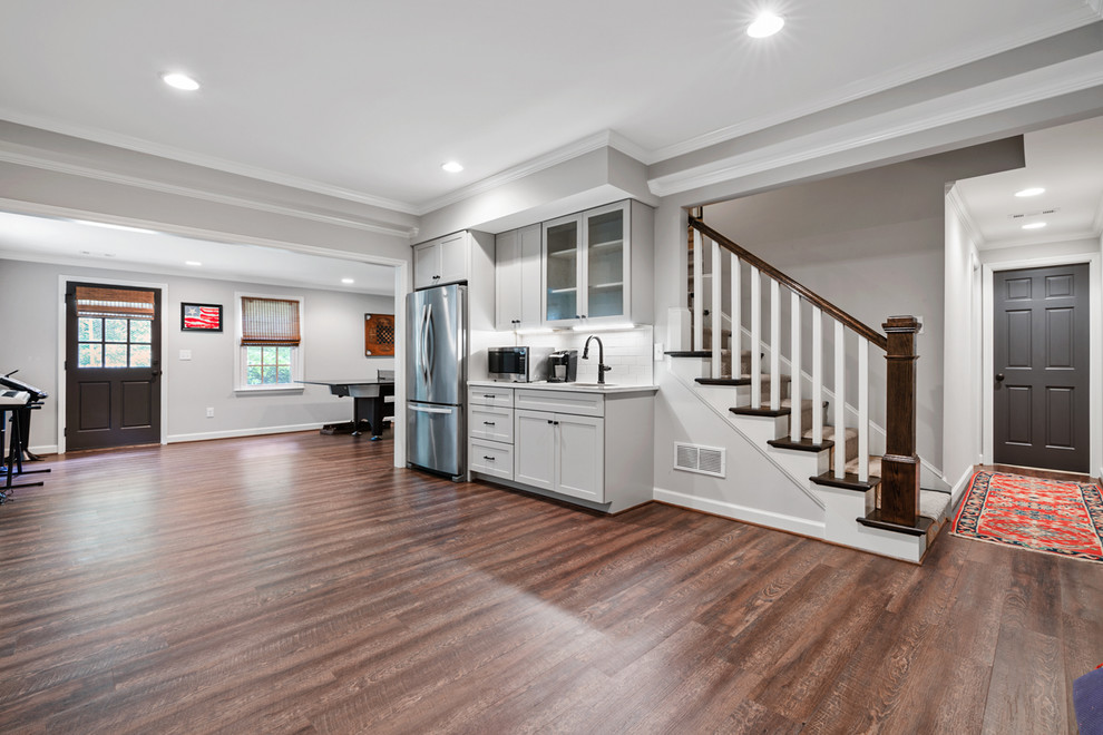 Photo of a large traditional walk-out basement in Atlanta with grey walls, vinyl flooring, a standard fireplace, a brick fireplace surround and brown floors.