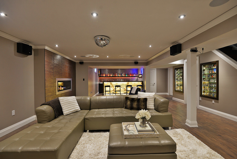 Example of a large trendy look-out laminate floor basement design in Toronto with gray walls, a standard fireplace and a metal fireplace