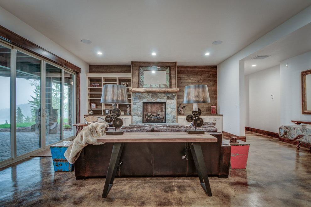 Basement - mid-sized rustic walk-out concrete floor basement idea in Seattle with white walls, a standard fireplace and a stone fireplace