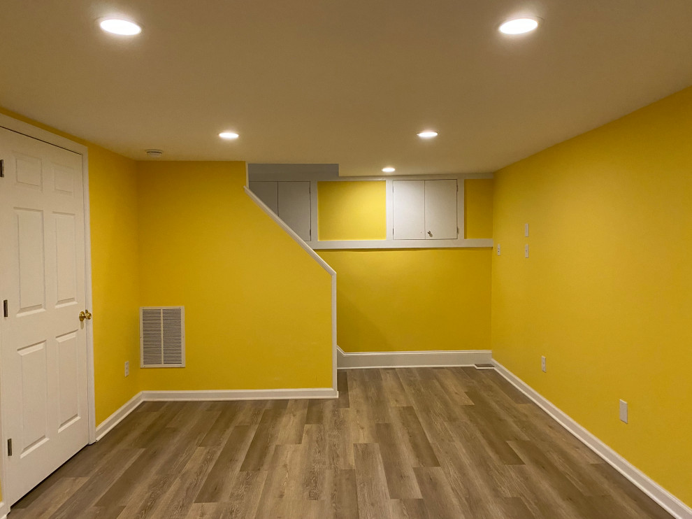 На фото: подвал с желтыми стенами, полом из винила и коричневым полом с