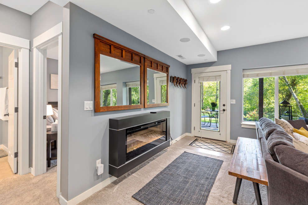 Medium sized classic walk-out basement in Seattle with grey walls, concrete flooring, a hanging fireplace, a metal fireplace surround and blue floors.