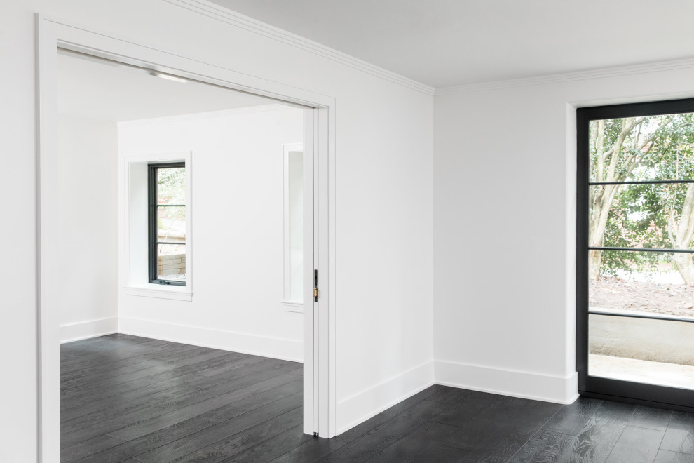 Exemple d'un sous-sol chic donnant sur l'extérieur et de taille moyenne avec un mur blanc, un sol en vinyl et un sol noir.