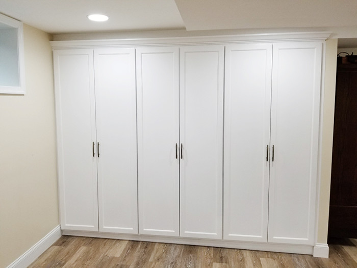 ワシントンD.C.にある低価格の中くらいなトランジショナルスタイルのおしゃれな地下室 (半地下 (ドアあり)、白い壁、クッションフロア、暖炉なし、マルチカラーの床) の写真