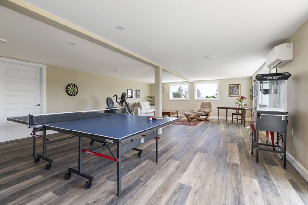 Huge cottage walk-out vinyl floor and multicolored floor basement game room photo in Other with white walls
