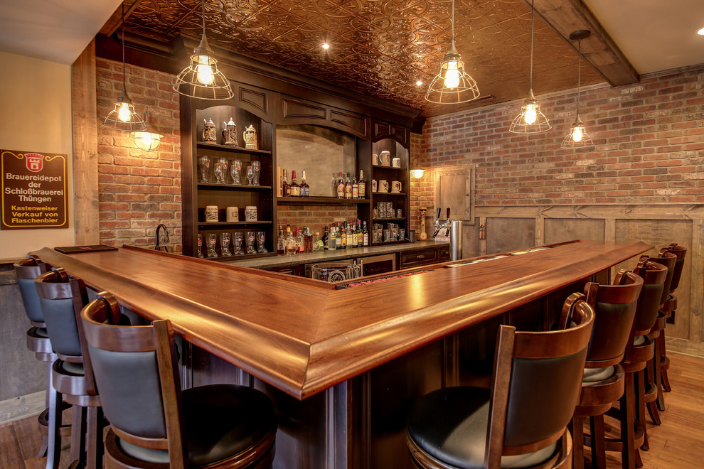 This is an example of a medium sized traditional home bar in Dallas with medium hardwood flooring and brown floors.