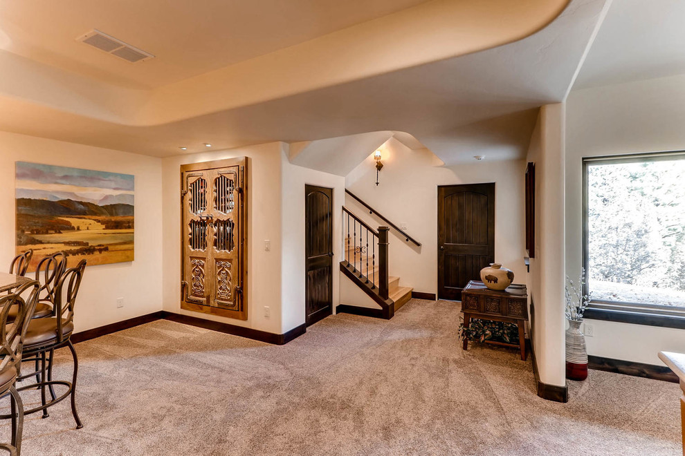 Example of a large southwest walk-out carpeted basement design in Denver with beige walls and no fireplace