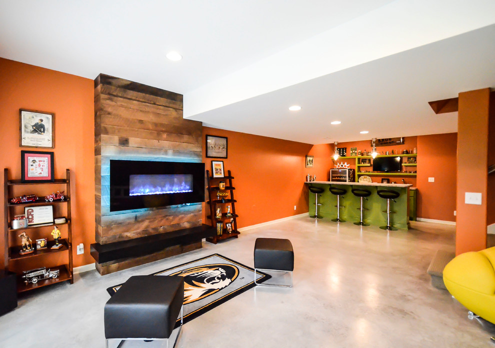 Aménagement d'un sous-sol moderne donnant sur l'extérieur et de taille moyenne avec un mur orange, sol en béton ciré et une cheminée ribbon.