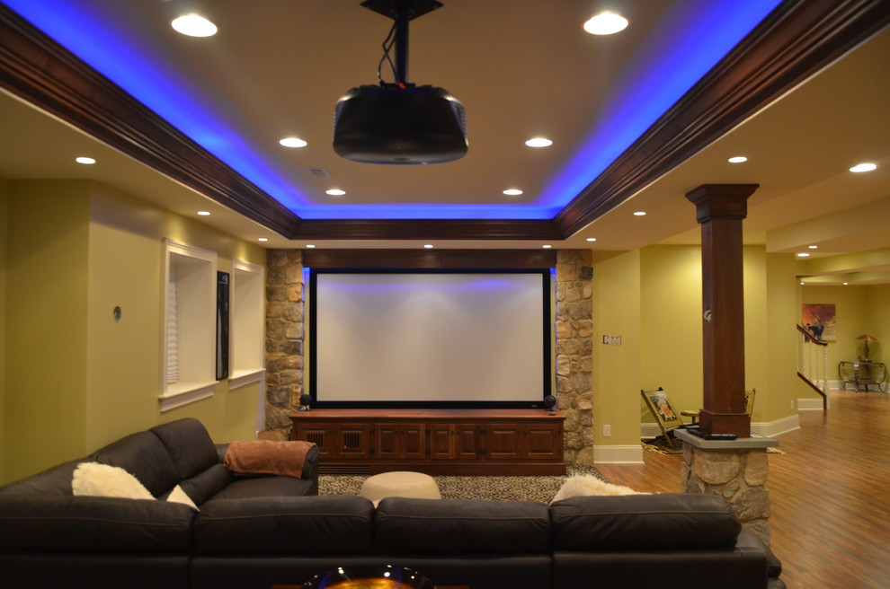 Example of a huge classic medium tone wood floor and brown floor home theater design in Philadelphia with green walls