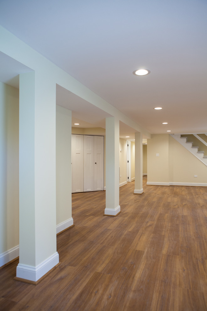 Large elegant look-out vinyl floor basement photo in Chicago with beige walls