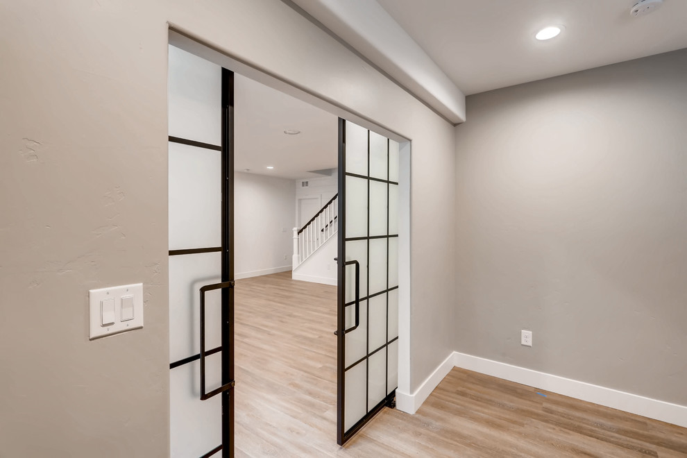 Basement - large underground light wood floor and beige floor basement idea in Denver with white walls and no fireplace