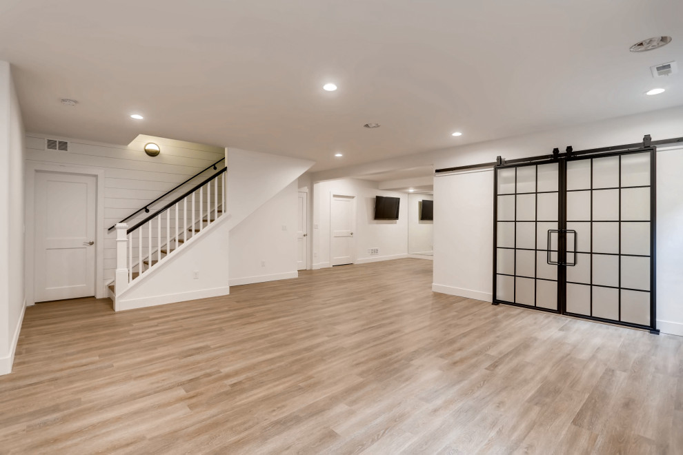 Inspiration for a mid-sized country laminate floor and shiplap wall basement remodel in Denver with white walls