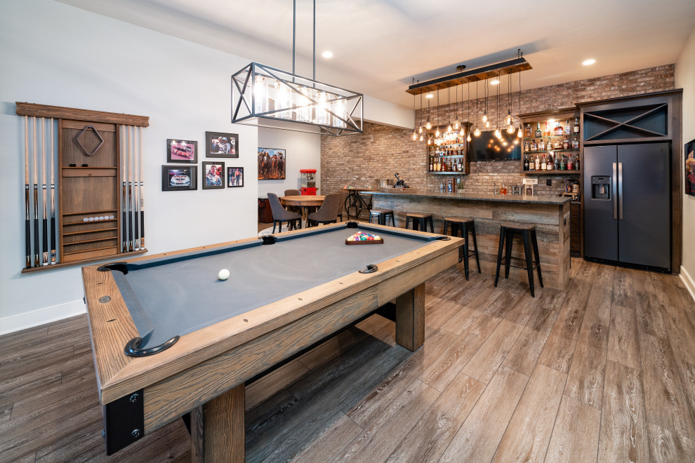 Modelo de sala de estar con barra de bar clásica renovada con paredes blancas, suelo de madera en tonos medios y suelo marrón