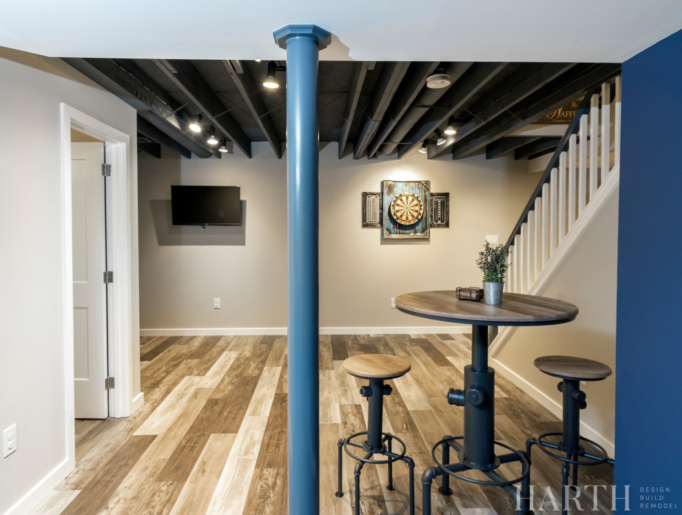 Inspiration for a medium sized industrial fully buried basement in Philadelphia with a home bar, beige walls, laminate floors, multi-coloured floors and exposed beams.