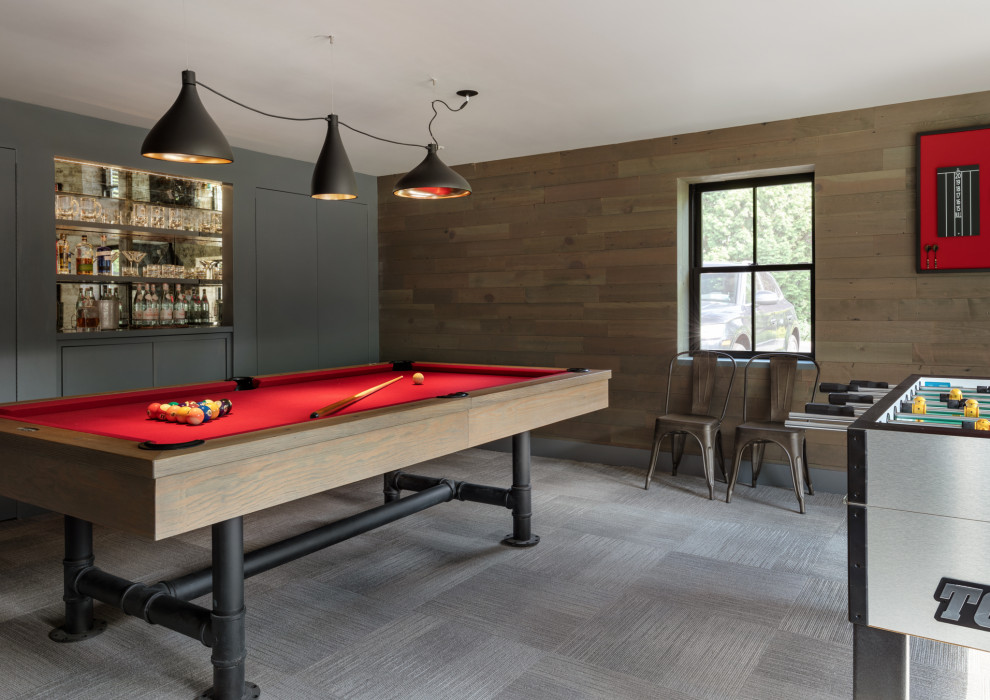 Immagine di una taverna design di medie dimensioni con sbocco, sala giochi, pareti marroni, moquette, pavimento grigio e pareti in legno
