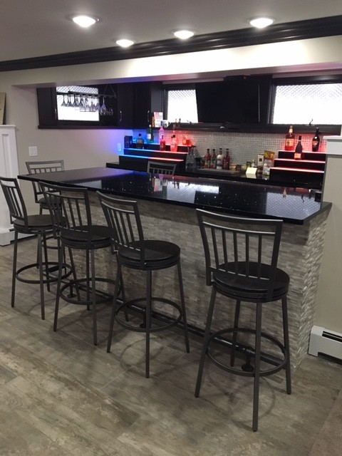 Medium sized contemporary home bar in New York with porcelain flooring and grey floors.