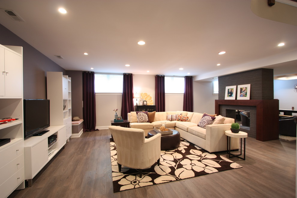 Inspiration for a large contemporary look-out medium tone wood floor and brown floor basement remodel in Chicago with gray walls and a tile fireplace