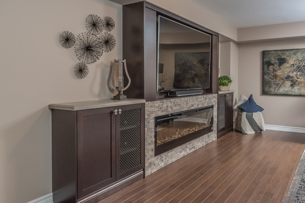 Inspiration for an expansive contemporary walk-out basement in Other with grey walls, medium hardwood flooring, a standard fireplace, a stone fireplace surround and brown floors.