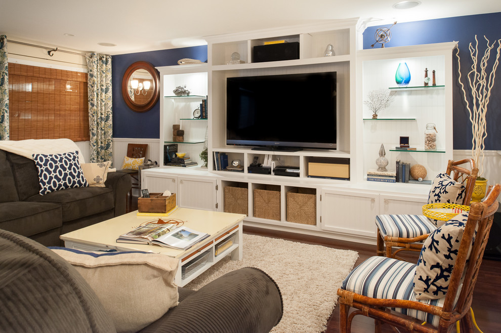 Imagen de sala de estar costera grande con suelo de madera oscura y paredes azules