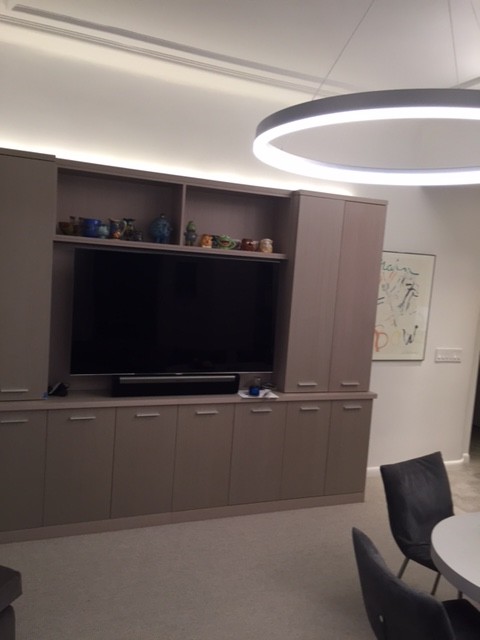 Photo of a medium sized contemporary basement in New York with white walls and carpet.
