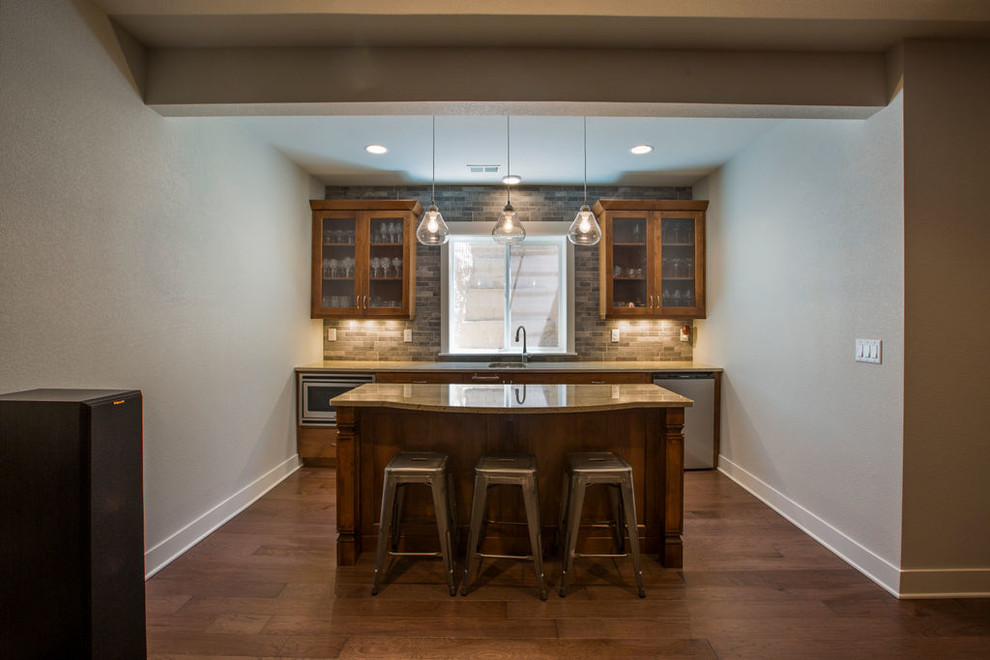 Photo of a large traditional look-out basement in Denver with grey walls, medium hardwood flooring and brown floors.