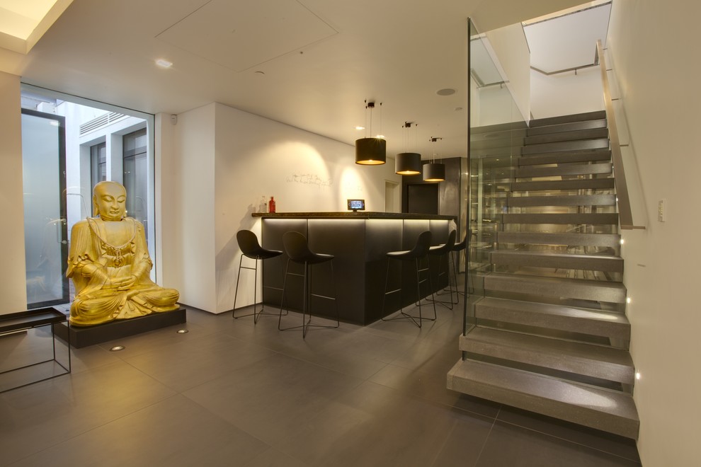 This is an example of a modern basement in London with grey floors.