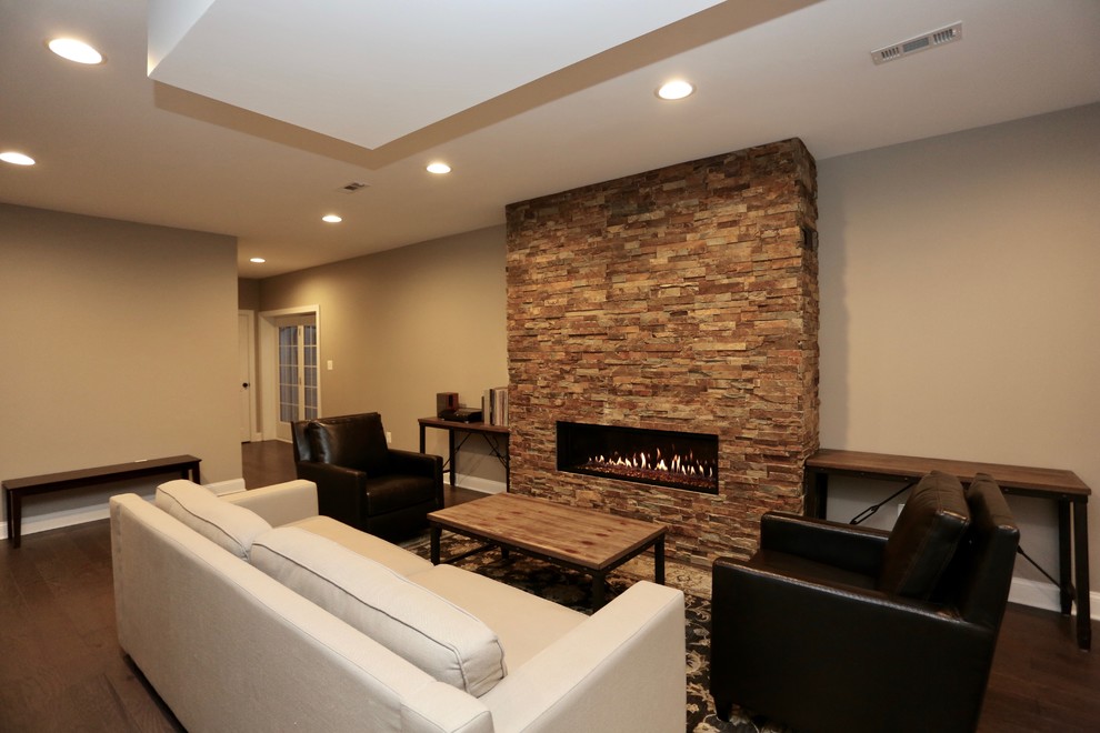 Basement - large contemporary underground dark wood floor and brown floor basement idea in DC Metro with brown walls, a ribbon fireplace and a stone fireplace