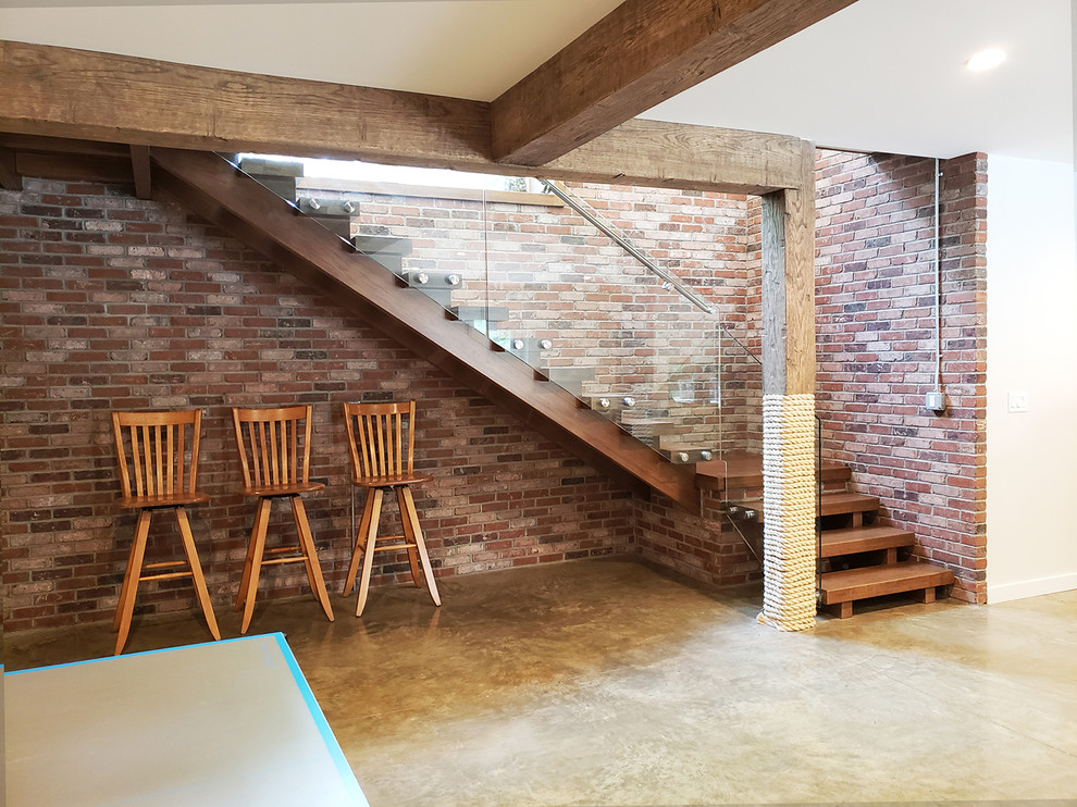 Immagine di una taverna design di medie dimensioni con sbocco, pareti multicolore, pavimento in cemento e pavimento grigio