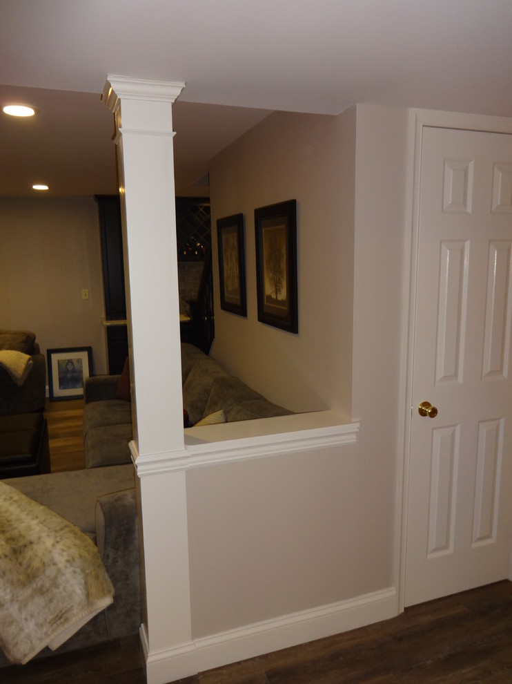 Cette photo montre un grand sous-sol chic semi-enterré avec un mur beige, un sol en vinyl et aucune cheminée.